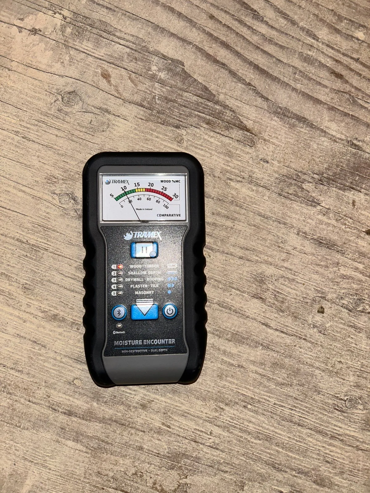 Pin-less moisture meter placed on an exposed plywood subfloor to confirm it has dried